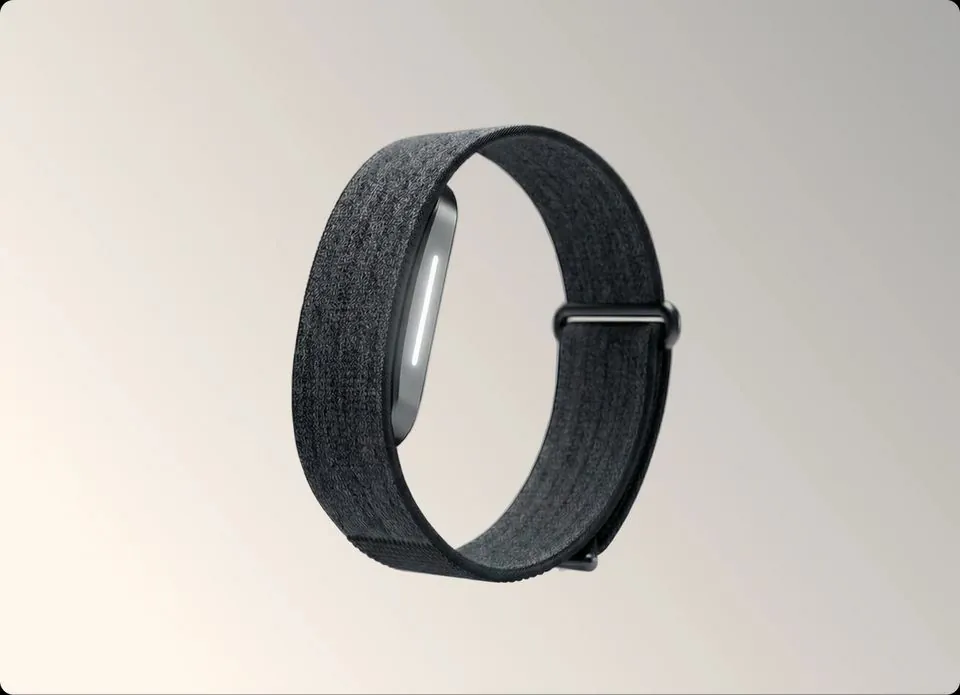 Hume Band 2.0 health tracker with dark fabric strap on a neutral background